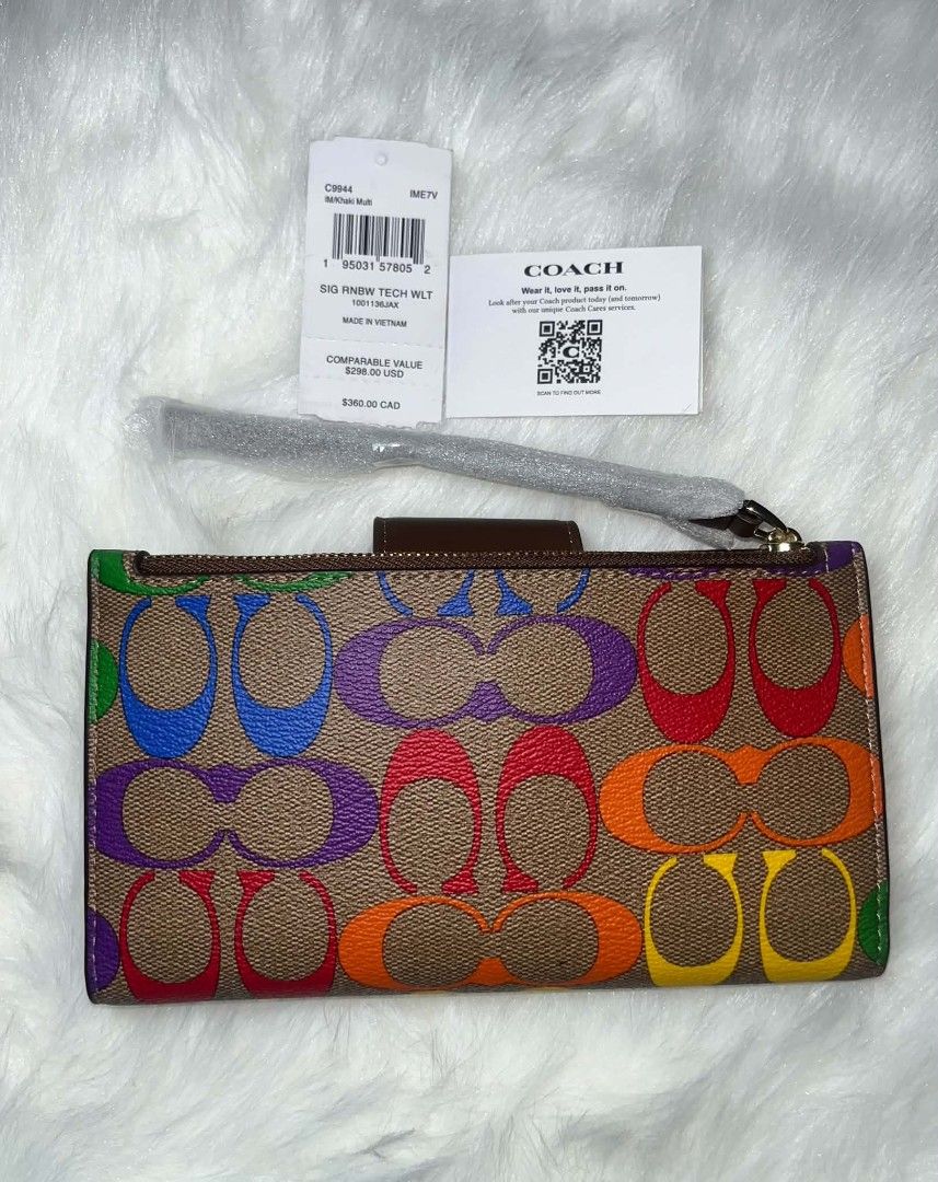 Coach Tech Phone Wallet Rainbow (Category: Wallets & Card holders) located in Imus. Submitted by maria_pilayo (Listing ID 1470280777, Image 3). Description: - 💯% Authentic Coach Tech Phone Wallet in Signature Canvas - Features a vibrant rainbow print with chic brown leather trim and gold-tone hardware - Dimensions: 19cm x 10.5cm - Includes a convenient wrist strap for easy carrying - Interior features multiple card slots and a clear ID window - 