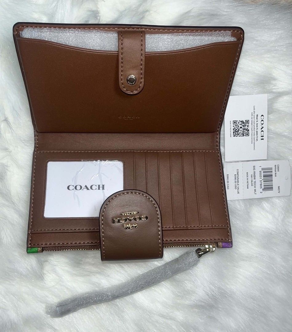 Coach Tech Phone Wallet Rainbow (Category: Wallets & Card holders) located in Imus. Submitted by maria_pilayo (Listing ID 1470280777, Image 2). Description: - 💯% Authentic Coach Tech Phone Wallet in Signature Canvas - Features a vibrant rainbow print with chic brown leather trim and gold-tone hardware - Dimensions: 19cm x 10.5cm - Includes a convenient wrist strap for easy carrying - Interior features multiple card slots and a clear ID window - 