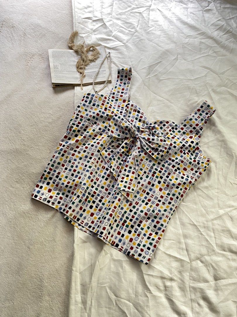 Colorful Pattern Tank Top with Bow Back Detail XL43 (Category: Sleeveless) located in Poro. Submitted by joyceyuu (Listing ID 1470167337, Image 3). Description: - Multi-color abstract square pattern on a white base - Sweetheart neckline with thick shoulder straps - Features a large fabric bow tie-up detail at the back - Lightweight and breathable fabric, ideal for warm weather - Versatile piece, easy to pair with denim shorts or skirts.