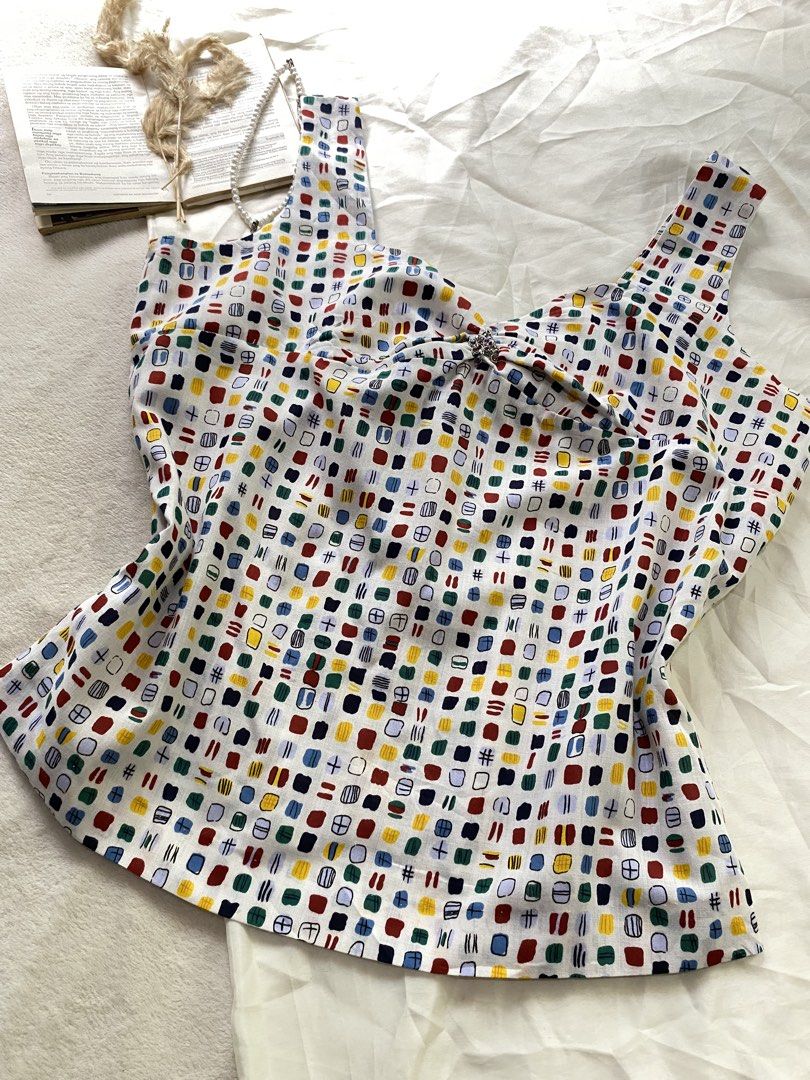 Colorful Pattern Tank Top with Bow Back Detail XL43 (Category: Sleeveless) located in Poro. Submitted by joyceyuu (Listing ID 1470167337, Image 2). Description: - Multi-color abstract square pattern on a white base - Sweetheart neckline with thick shoulder straps - Features a large fabric bow tie-up detail at the back - Lightweight and breathable fabric, ideal for warm weather - Versatile piece, easy to pair with denim shorts or skirts.