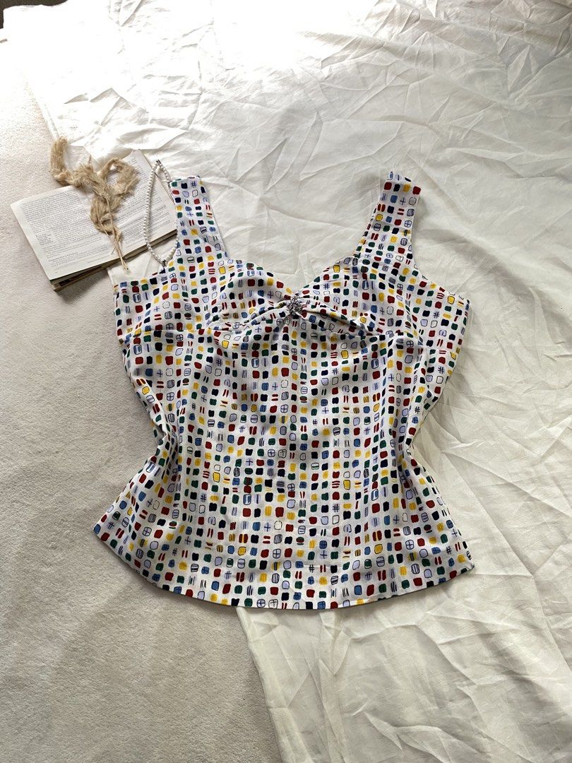 Colorful Pattern Tank Top with Bow Back Detail XL43 (Category: Sleeveless) located in Poro. Submitted by joyceyuu (Listing ID 1470167337, Image 1). Description: - Multi-color abstract square pattern on a white base - Sweetheart neckline with thick shoulder straps - Features a large fabric bow tie-up detail at the back - Lightweight and breathable fabric, ideal for warm weather - Versatile piece, easy to pair with denim shorts or skirts.