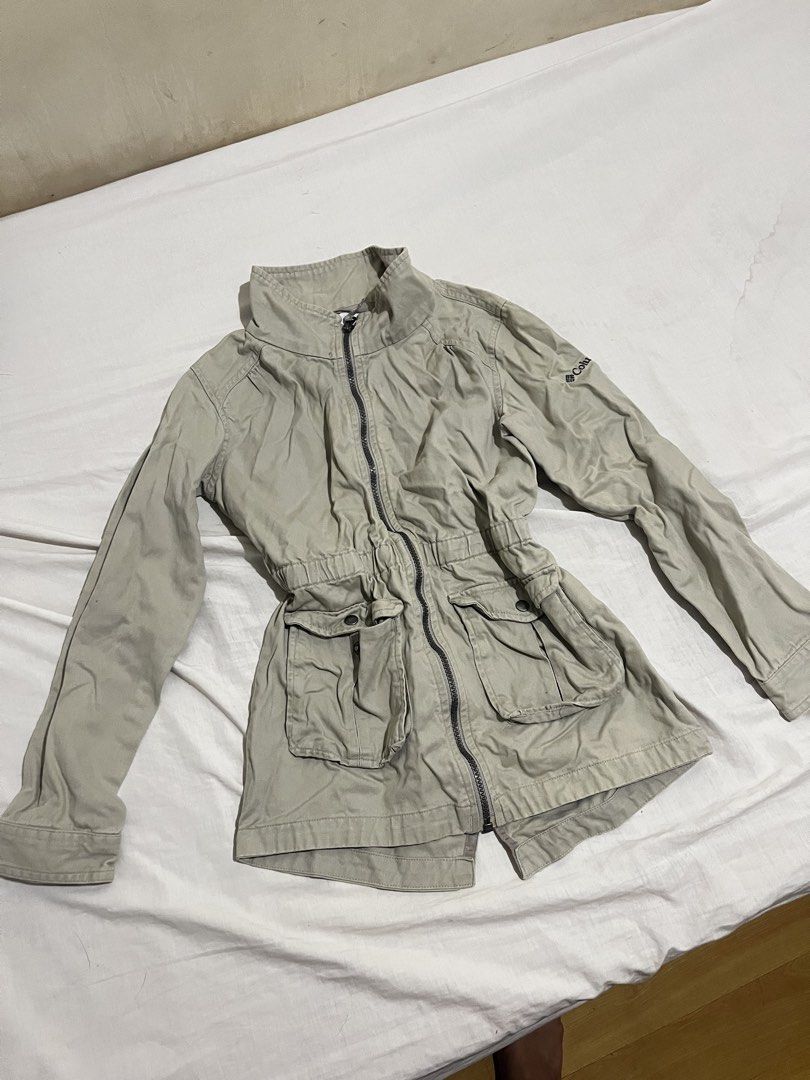 Columbia Beige Utility Jacket with Drawstring Waist (Category: Coats, Jackets and Outerwear) located in San Fernando. Submitted by angelhave_wings (Listing ID 1470290956, Image 1). Description: - Brand: Columbia - Color: Beige - Material: Durable cotton canvas - Design: High collar, full zip front, and button cuffs - Pockets: Double front utility pockets with flap closures - Silhouette: Fitted elasticized waist for a structured look - Condition: 
