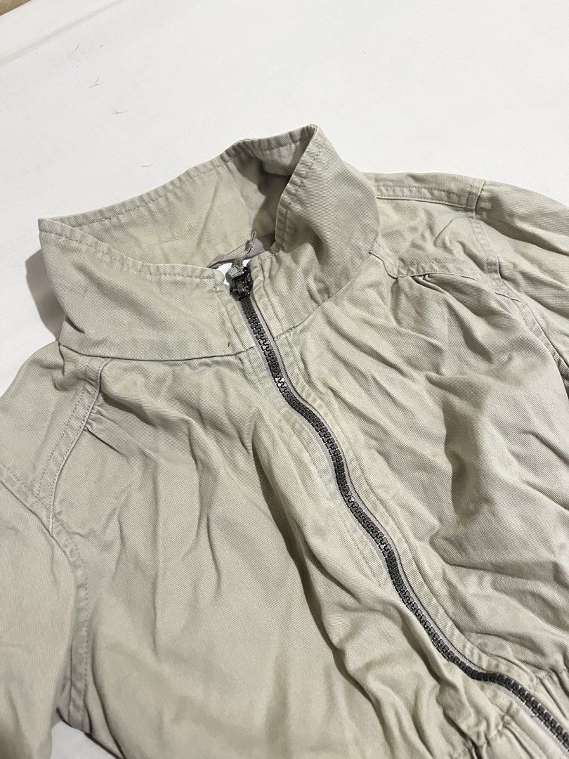 Columbia Beige Utility Jacket with Drawstring Waist (Category: Coats, Jackets and Outerwear) located in San Fernando. Submitted by angelhave_wings (Listing ID 1470290956, Image 3). Description: - Brand: Columbia - Color: Beige - Material: Durable cotton canvas - Design: High collar, full zip front, and button cuffs - Pockets: Double front utility pockets with flap closures - Silhouette: Fitted elasticized waist for a structured look - Condition: 