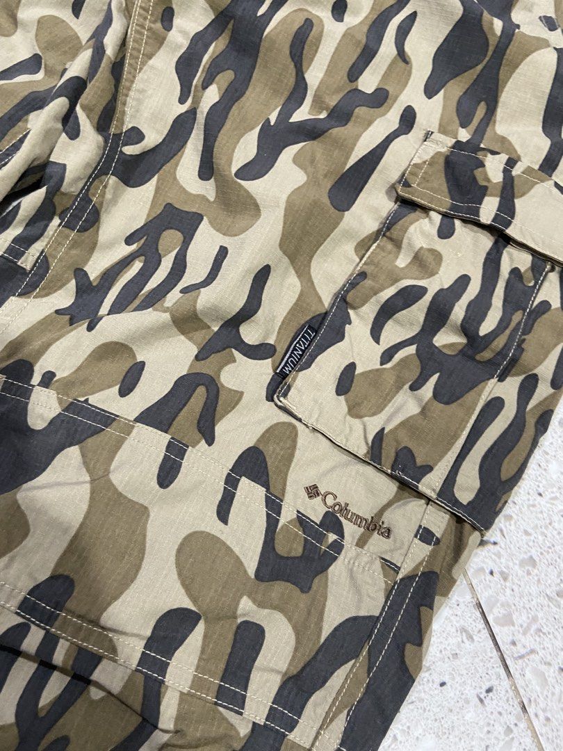 Columbia Titanium Camo Cargo Pants Men M (Category: Trousers) located in Calumpit. Submitted by Ketchi (Listing ID 1470262022, Image 3). Description: - Brand: Columbia Titanium - Style: Cargo pants in green camo pattern - Size: Men's Medium - Material: 100% durable nylon ripstop fabric - Fit: Elastic waistband with integrated adjustable buckle belt and drawstring leg openings - Storage: Multiple functional cargo pockets - Details: Branded embroid