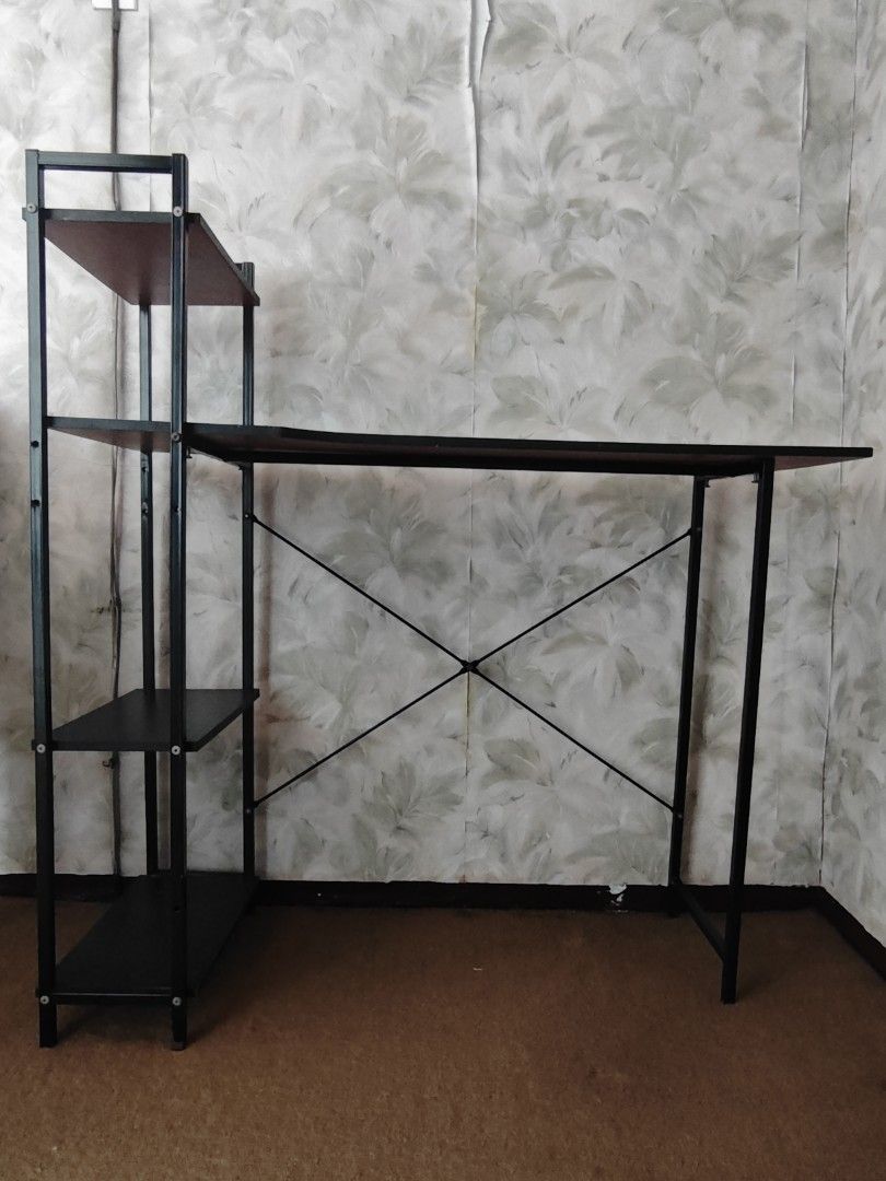 Computer desk with integrated bookshelves / study table (Category: Tables & Sets) located in Paranaque City. Submitted by anonymoosh (Listing ID 1470228497, Image 1). Description: - Design: Stylish black metal frame with brown wooden surfaces - Storage: Built-in multi-tier shelving unit on the side for extra space - Dimensions: 100 cm (L) x 31 cm (W) x 104 cm (H) - Condition: Clean and well-maintained with no issues - Reason for selling: Upgraded