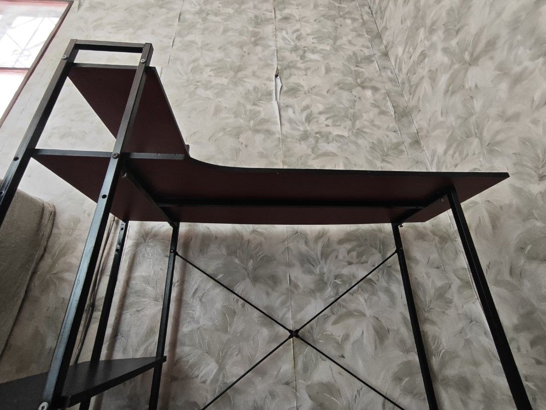 Computer desk with integrated bookshelves / study table (Category: Tables & Sets) located in Paranaque City. Submitted by anonymoosh (Listing ID 1470228497, Image 2). Description: - Design: Stylish black metal frame with brown wooden surfaces - Storage: Built-in multi-tier shelving unit on the side for extra space - Dimensions: 100 cm (L) x 31 cm (W) x 104 cm (H) - Condition: Clean and well-maintained with no issues - Reason for selling: Upgraded