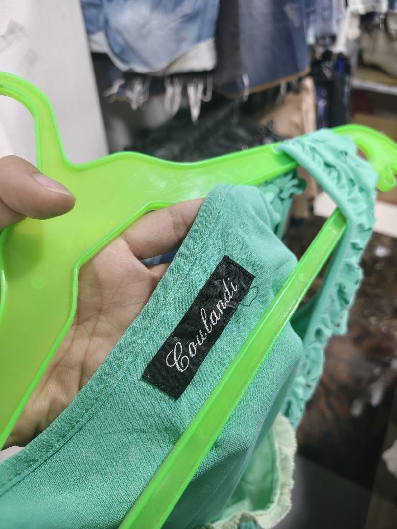 Coulandi Green Sleeveless Ruffle Top (Category: Sleeveless) located in Binan City. Submitted by makinpeso0622 (Listing ID 1470183438, Image 3). Description: - Brand: Coulandi - Style: Green sleeveless top with V-neckline and hem ruffles - Details: Cut-out floral patterns and visible inner lace layer at the chest - Fabric: Soft, lightweight, and cool to wear - Condition: Good, clean, and ready to wear - Perfect for: Casual days out with jeans or s