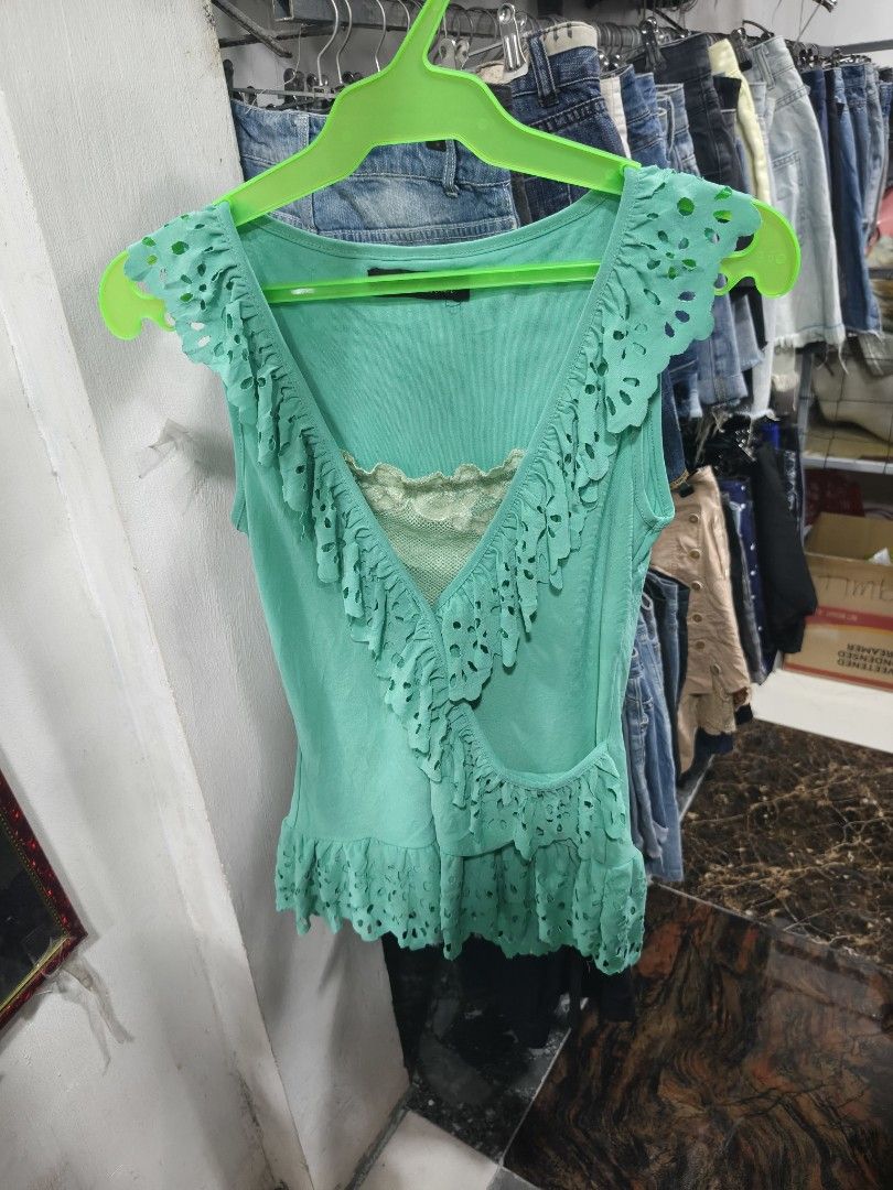 Coulandi Green Sleeveless Ruffle Top (Category: Sleeveless) located in Binan City. Submitted by makinpeso0622 (Listing ID 1470183438, Image 1). Description: - Brand: Coulandi - Style: Green sleeveless top with V-neckline and hem ruffles - Details: Cut-out floral patterns and visible inner lace layer at the chest - Fabric: Soft, lightweight, and cool to wear - Condition: Good, clean, and ready to wear - Perfect for: Casual days out with jeans or s