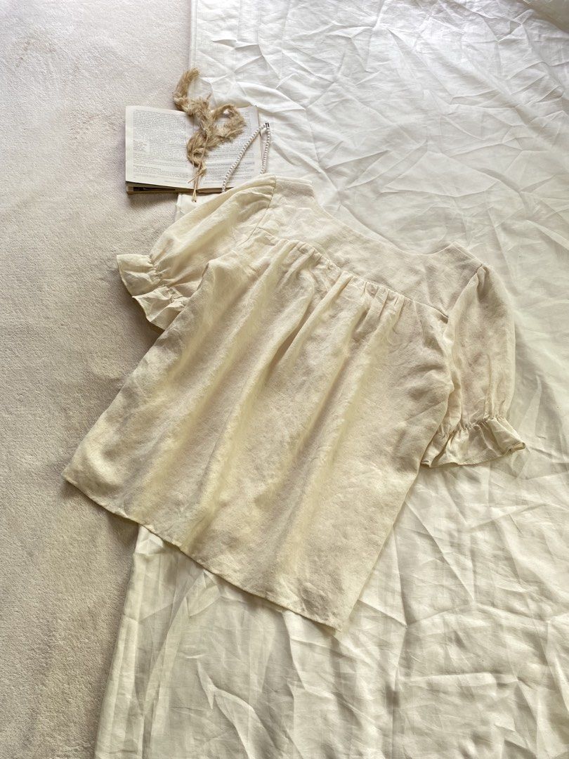 Cream Square Neck Puff Sleeve Blouse Medium 38 (Category: Blouses) located in Poro. Submitted by joyceyuu (Listing ID 1470167487, Image 3). Description: - Color: Cream - Style: Square neckline, gathered bust, and short puff sleeves with ruffled cuffs - Fit: Relaxed fit through the body - Fabric: Soft, textured, and lightweight - Versatility: Easy to pair with high-waisted jeans or skirts - Condition: Excellent, worn only a few times with no flaws