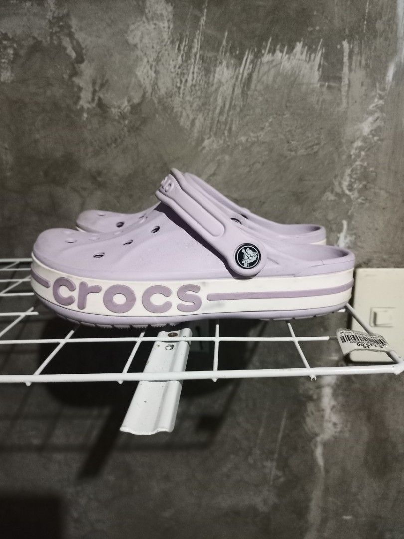 Crocs Bayaband Clog Lavender Light Purple (Category: Slippers and slides) located in Mabalacat. Submitted by hasashoe (Listing ID 1470279318, Image 1). Description: - Color: Light purple with white stripe and bold Crocs lettering - Size: Men's US 4 / Women's US 6 (indicated on bottom tread) - Condition: Pre-owned with minor dirt on the soles - Features: Easy slip-on style, top ventilation holes, and pivoting heel strap - Perfect for casual wear, 