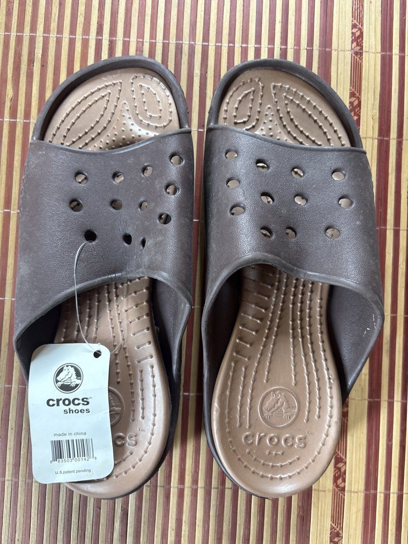 Crocs Brown Slide Sandals Size M9/W11 (Category: Slippers and slides) located in Pasig City. Submitted by coolphoenix-29ac (Listing ID 1470184226, Image 2). Description: - Brand: Crocs - Style: Slide sandals with cutout details and textured footbed - Condition: Brand new with original store tag attached - Color: Brown - Size: Men's 9 / Women's 11 - Origin: Made in China - Slip-on design for easy wear.