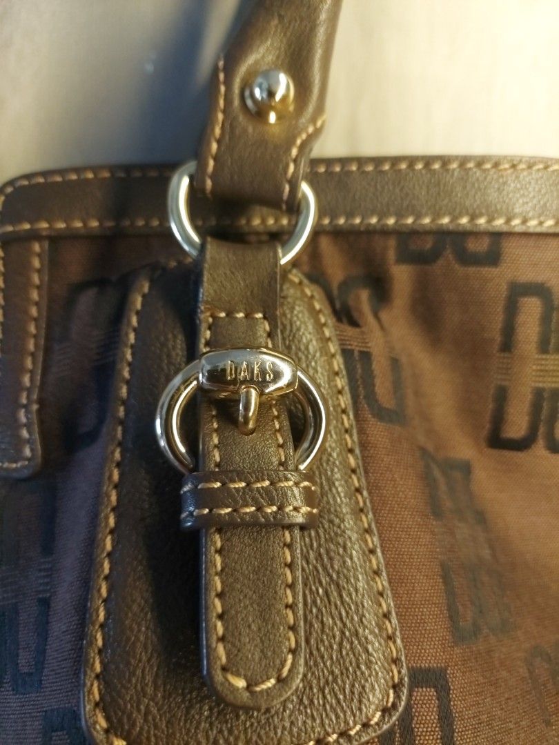 DAKS Brown Monogram Shoulder Bag (Category: Shoulder Bags) located in Quezon City. Submitted by never_a_clutter (Listing ID 1470168418, Image 2). Description: - Authentic DAKS shoulder bag in classic brown monogram - Durable leather trim, handles, and base reinforcement - Features stylish dual shoulder straps and buckle accent hardware - Spacious interior that easily fits daily essentials - gold hardware super minimal scratch - corners few rubs, 
