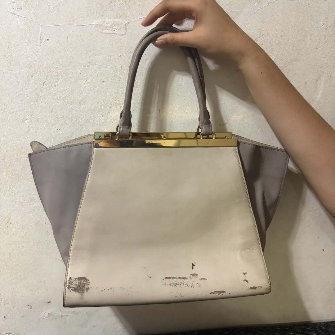 Daniel Hechter cream and grey leather handbag (Category: Luxury Bags & Wallets) located in Manila. Submitted by youresovaiineee (Listing ID 1470266292, Image 2). Description: - Brand: Daniel Hechter - Material: Cream and grey leather with gold-tone hardware - Design: Double top handles and front zip pocket - Interior: Geometric-patterned lining with multiple slip and zip compartments - Condition: Noticeable scuffs and peeling on the bottom base l