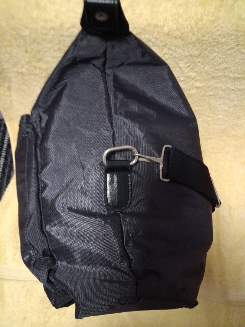Dark Grey Travel Bag with Handles (Category: Sling Bags) located in Angeles City. Submitted by anneps (Listing ID 1470216357, Image 2). Description: - Color: Dark grey - Material: Durable and lightweight nylon - Compartments: Large main compartment with secure zipper, plus a convenient front zippered pocket - Carrying options: Sturdy dual handles and adjustable longer shoulder straps - Design: Minimalist branding tag - Best used for: Weekend trip