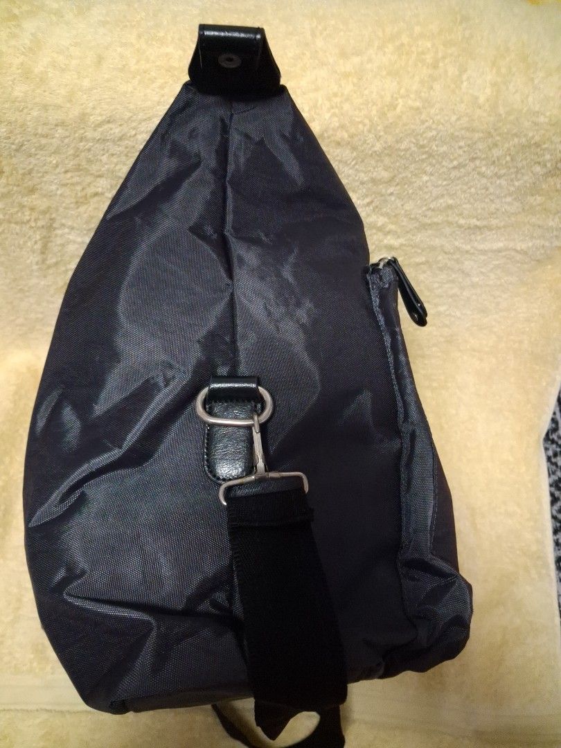 Dark Grey Travel Bag with Handles (Category: Sling Bags) located in Angeles City. Submitted by anneps (Listing ID 1470216357, Image 3). Description: - Color: Dark grey - Material: Durable and lightweight nylon - Compartments: Large main compartment with secure zipper, plus a convenient front zippered pocket - Carrying options: Sturdy dual handles and adjustable longer shoulder straps - Design: Minimalist branding tag - Best used for: Weekend trip
