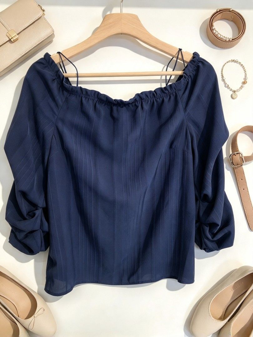 Dark Navy Off-Shoulder Ruffle Blouse (Category: Blouses) located in Batangas. Submitted by mace2014 (Listing ID 1470217623, Image 1). Description: - Color: Dark navy blue - Design: Off-shoulder neckline with stretchy elastic ruffle trim - Fit: Relaxed fit with subtle vertical fabric stripes - Material: Lightweight and comfortable - Styling: Easy to pair with jeans or a skirt for casual days.