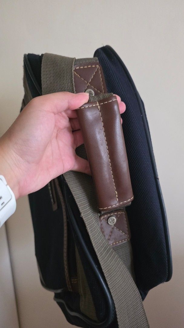 Delsey Canvas Messenger Bag with Shoulder Strap (Category: Sling Bags) located in Las Pinas. Submitted by lovedbymariee (Listing ID 1470187160, Image 2). Description: - Brand: Delsey - Color: Dark navy blue canvas with brown leather trim - Design: Front zippered pocket with olive green stripe and included padlock - Comfort: Adjustable canvas shoulder strap with padded grip handle.