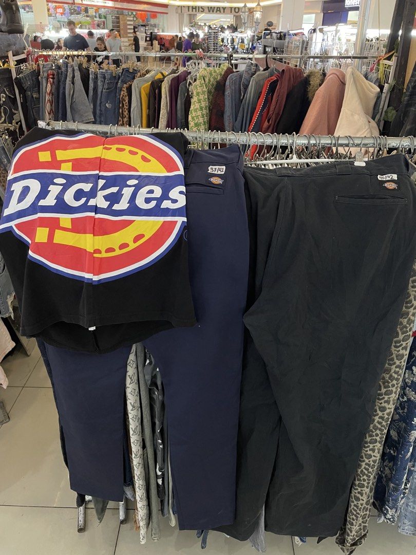 Dickies branded black t-shirt and work pants bundle (Category: Tshirts & Polo Shirts ) located in Cainta. Submitted by riszizlux (Listing ID 1470248759, Image 1). Description: - Brand: Dickies Navy 37by41 Black 40by41 - Bundle includes: 1 black short-sleeve shirt with large front logo graphic, 1 pair of navy blue work pants, and 1 pair of dark grey/black work pants - Material: Heavy-duty, durable fabric built for daily wear - Details: Standard Di