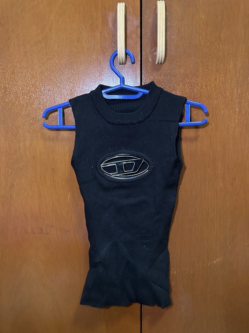 Black Sleeveless Ribbed Knit Top With Logo (Category: Sleeveless) located in Las Pinas. Submitted by michywoop (Listing ID 1470322100, Image 2). Description: - Style: Sleeveless ribbed knit top with high neckline and fitted silhouette - Detail: Iconic large silver Diesel oval logo hardware on the chest - Material: Soft knit with great stretch for a comfortable fit - Condition: Clean and well-maintained - Shipping & Meetups: Ships fast from the Ph