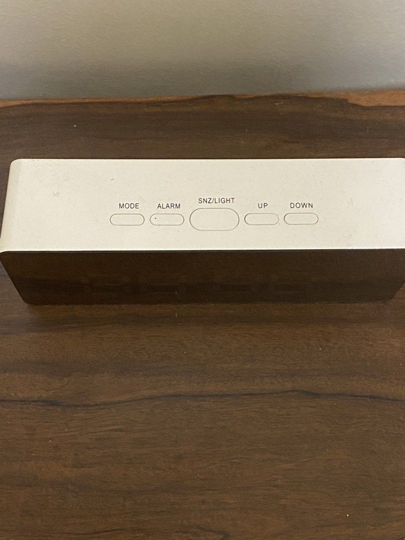 Digital LED Mirror Alarm Clock with White Casing (Category: Clocks) located in Quezon City. Submitted by qc_declutter (Listing ID 1470261488, Image 3). Description: - Color/Style: White digital clock with a sleek mirror display - Display: Bright LED numbers for clear time-reading day or night - Controls: Convenient top buttons for mode, alarm, snooze/light, up, and down - Design: Simple and modern, perfect for bedside tables or office desks - Pow