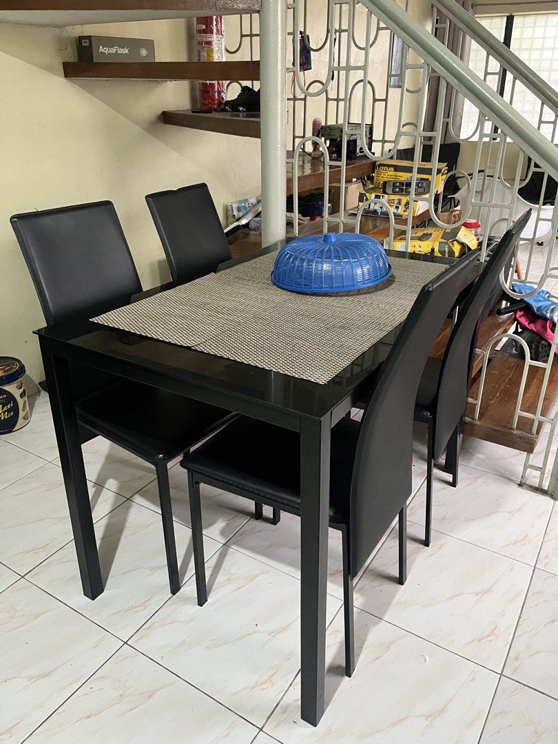 Dining Table (Category: Tables & Sets) located in Pasig City. Submitted by espanosam__ (Listing ID 1470163741, Image 2). Description: - Complete set: 1 black rectangular dining table and 4 matching chairs - Sleek glass-like top surface with a sturdy solid frame - Includes a stylish textured woven table mat - Clean, modern aesthetic ideal for apartments and compact spaces - Low maintenance and very easy to wipe clean.