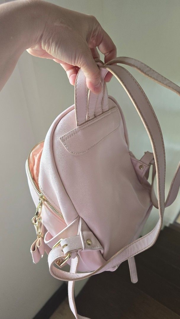 Disney Minnie Mouse Pink Mini Backpack with Bow (Category: Babies & Kids Fashion) located in Quezon City. Submitted by nini25ic (Listing ID 1470153792, Image 3). Description: - Color: Light pink with adorable Minnie Mouse print - Pocket: Front flap pocket with a cute heart-shaped turn-lock closure - Detail: Sweet little bow attached near the base - Interior: Pink satin lining with a secure zip compartment and slip pockets - Straps: Comfortable, a