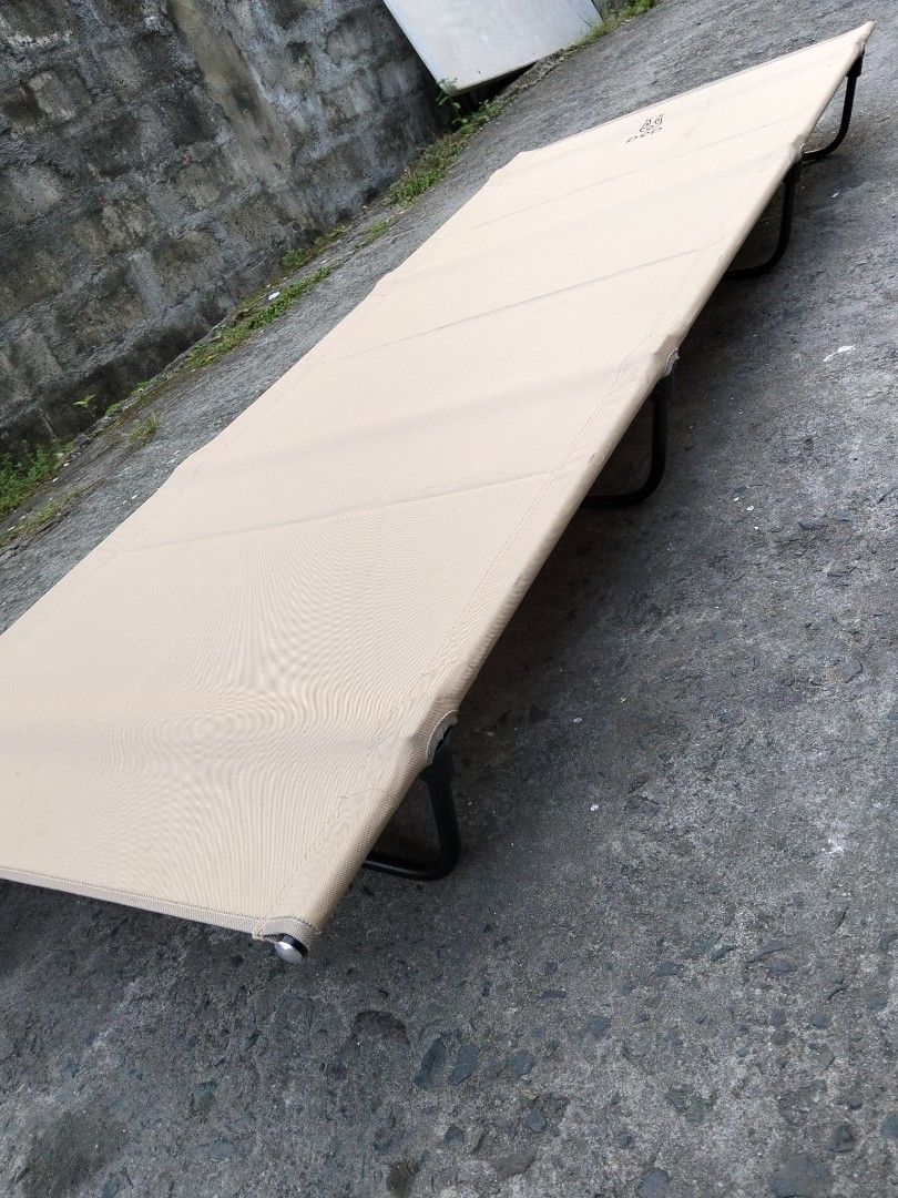 DOD Camping Cot Tan Color Portable Bed (Category: Hiking & Camping) located in Abucay. Submitted by cristineca20489 (Listing ID 1470334100, Image 1). Description: - Brand: DOD Camping Cot - Color: Stylish Tan - Weight: Lightweight at only 2.6kg - Capacity: Sturdy build supports up to 120kg - Setup: Fast and easy assembly with black metal legs and poles - Portability: Packs down compactly into the included carry bag - Versatility: Ideal for outdoo