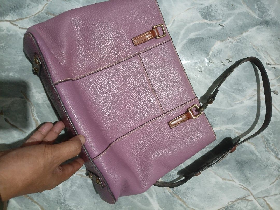 Dooney & Bourke Purple Pebbled Leather Shoulder Bag (Category: Luxury Bags & Wallets) located in Cavite. Submitted by jaimebuala31560 (Listing ID 1470193143, Image 3). Description: - Authentic Dooney & Bourke shoulder bag in purple pebbled leather - Contrast brown leather trim and polished gold-tone hardware - Adjustable strap equipped with a comfort shoulder pad - Exterior front slip pocket featuring the brand logo plaque - Flat structured base 