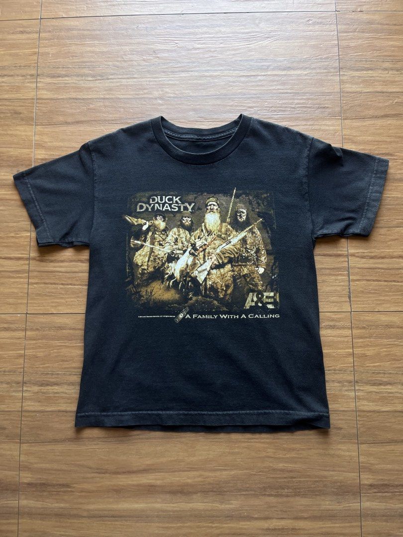 Duck Dynasty Tee (Category: Tshirts & Polo Shirts ) located in Davao. Submitted by spilled.bins (Listing ID 1470274568, Image 1). Description: Duck Dynasty Tee Dated 2012 Width: 17.9in Length: 23in XS/S Measurement Used Fade | Cracks Excellent Condition . Mine: ₱450 +shipping fee on top . Model Reference: Height: 5’5 feet Weight: 68kg.