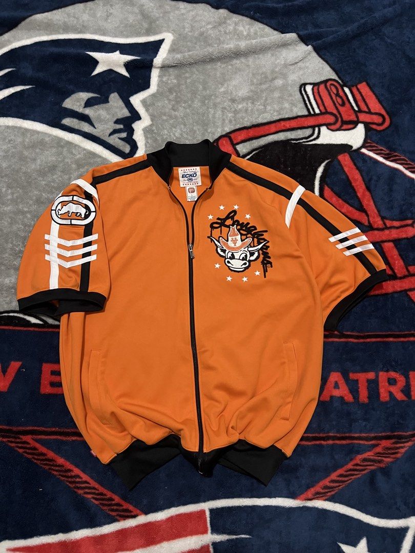 Ecko Unltd. Short Sleeve Track Jacket Orange (Category: Coats, Jackets and Outerwear) located in Tanza. Submitted by 1954_street (Listing ID 1470305986, Image 1). Description: ECKO large 27x31 excellent condition 1500 - Brand: Ecko Unltd. (Official Tagged Product) - Size: Large - Color: Vibrant orange with black/white contrast piping - Design: Large embroidered cowboy bull logo on chest, graphics on upper and lower back - Features: Full zip closu