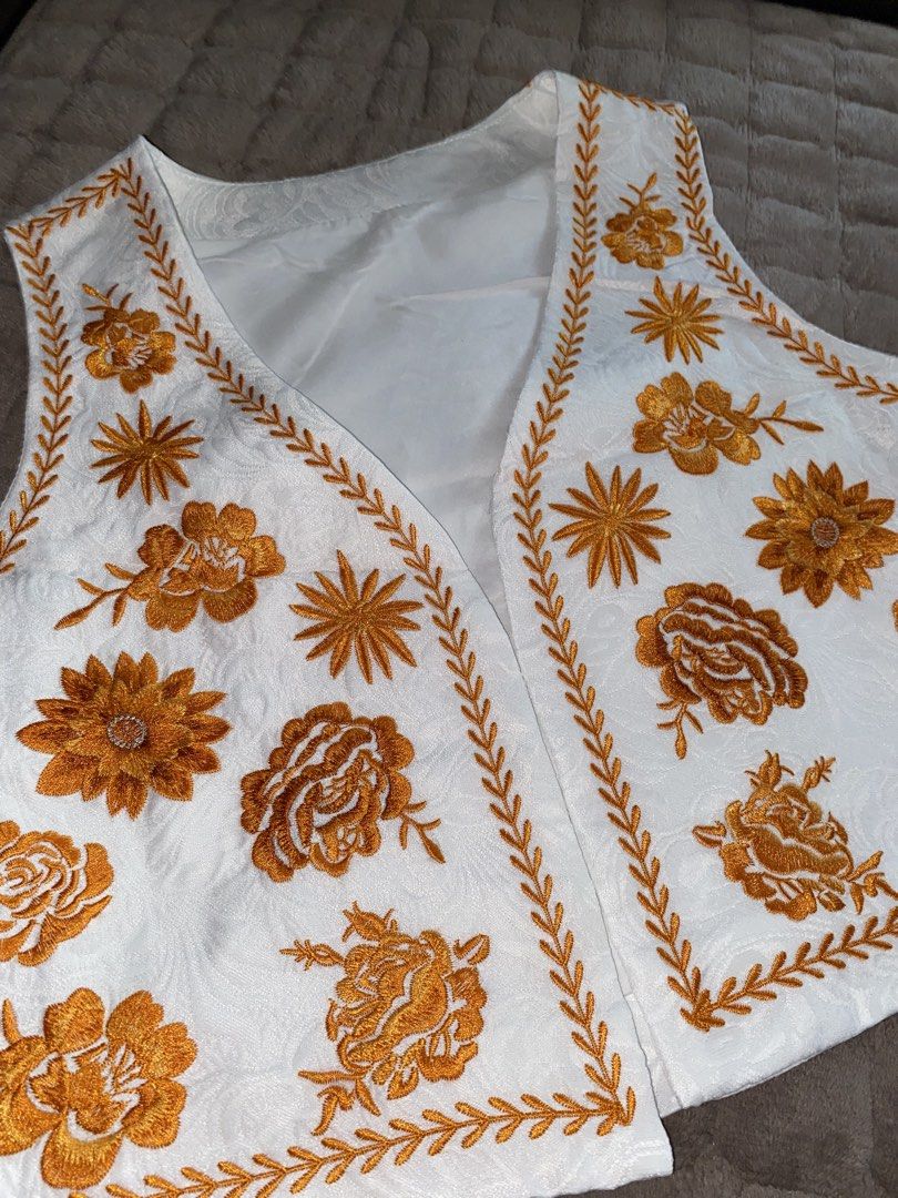 Embroidered Floral Vest (Category: Sleeveless) located in Cavite. Submitted by helloize (Listing ID 1470221951, Image 2). Description: - Color: White with intricate orange floral embroidery - Design: Sleeveless, open front with detailed stitching on front panels - Interior: Fully lined for comfort and quality - Versatility: Perfect layering piece for both casual outfits and special occasions - Condition: Clean fabric and well-maintained details.