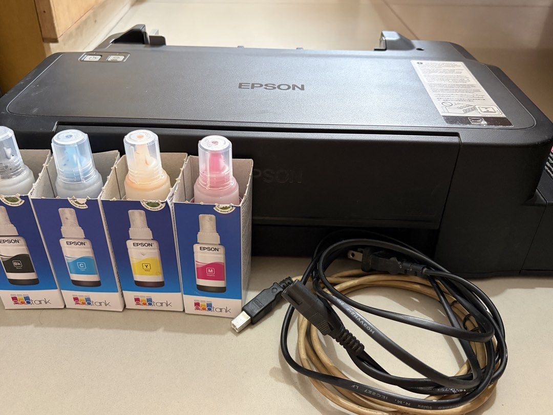 Epson L121 EcoTank Printer with Ink Bottles and Cables (Category: Printers, Scanners & Copiers) located in Manila. Submitted by piafreebee_316 (Listing ID 1470206830, Image 1). Description: Epson L121 Printer FOR SALE - well-used; gumagana pa siya but kinakain nya yung paper. kayo nalang po magpa-ayos - full inks pa, kakarefill lang; with inks authentic ink included - black, cyan, yellow, magenta (bought in national bookstore) - damage rear paper