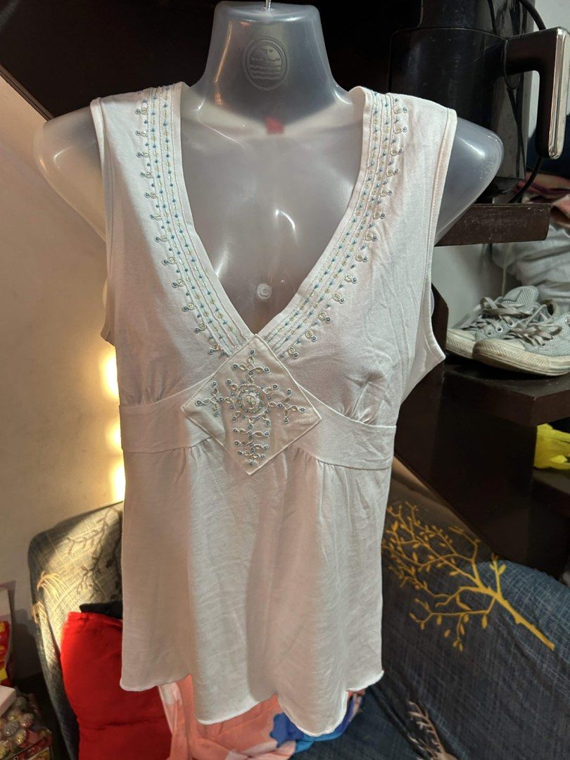 Esprit White Beaded V-Neck Sleeveless Top (Category: Sleeveless) located in Manila. Submitted by lovely.453 (Listing ID 1470267797, Image 1). Description: Esprit white sleeveless top with deep V-neck and beaded detailing. Empire waist cut with self-tie straps at the back. Delicate beadwork along the neckline and front diamond patch. Red brand tag at the collar. Spare beads pouch still attached to the label. Lightweight cotton fabric..