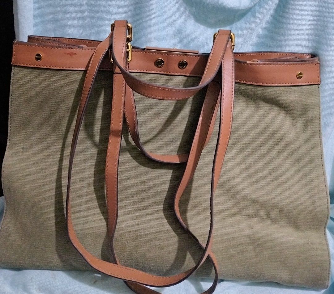 Fendi Peekaboo X-Tote (Category: Tote Bags) located in Valenzuela. Submitted by nurzdara28 (Listing ID 1470309156, Image 2). Description: Fendi Peekaboo X-Tote in a green canvas design with a brown leather serial tag. Brand / Model: Fendi Peekaboo X-Tote (Canvas / Green) Design Features: Green canvas body, gold-tone hardware snap buttons, and an interior leather tag with serial/code imprint. Aesthetic & Style: A structured luxury shoulder or hand