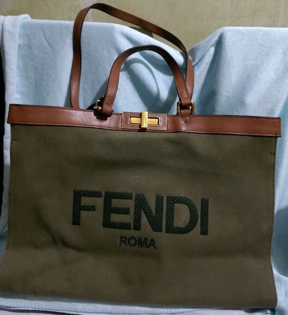 Fendi Peekaboo X-Tote (Category: Tote Bags) located in Valenzuela. Submitted by nurzdara28 (Listing ID 1470309156, Image 1). Description: Fendi Peekaboo X-Tote in a green canvas design with a brown leather serial tag. Brand / Model: Fendi Peekaboo X-Tote (Canvas / Green) Design Features: Green canvas body, gold-tone hardware snap buttons, and an interior leather tag with serial/code imprint. Aesthetic & Style: A structured luxury shoulder or hand
