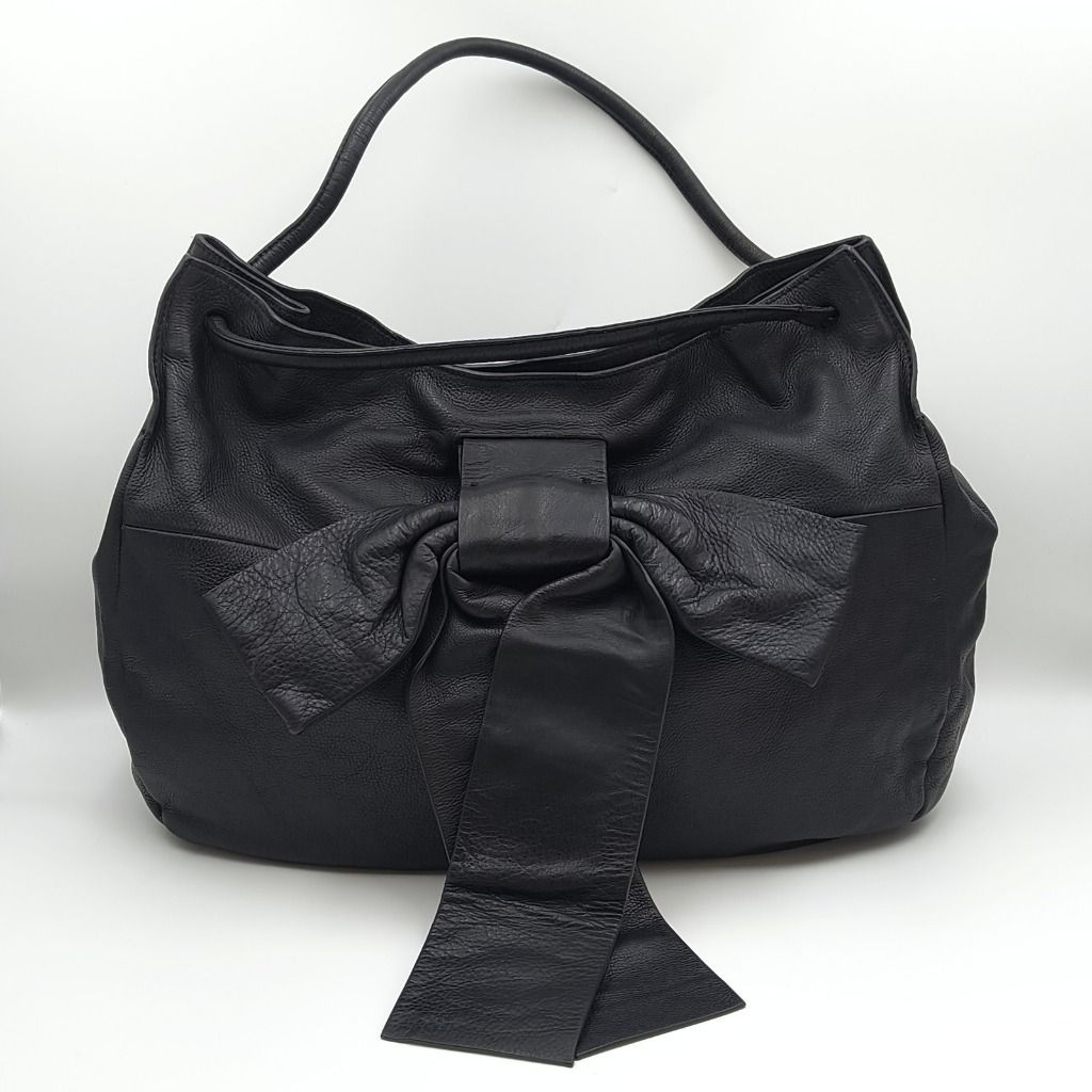 Ferragamo Large Ribbon Tote Bag Black (Category: Luxury Bags & Wallets) located in Lapu Lapu. Submitted by theluxxaffair (Listing ID 1470196400, Image 1). Description: Guaranteed authentic large Ferragamo ribbon tote bag crafted in black grained calfskin leather, featuring an oversized leather bow on the front. Its relaxed silhouette is complemented by two leather shoulder handles, a spacious fabric-lined interior, and an interior zippered pocket