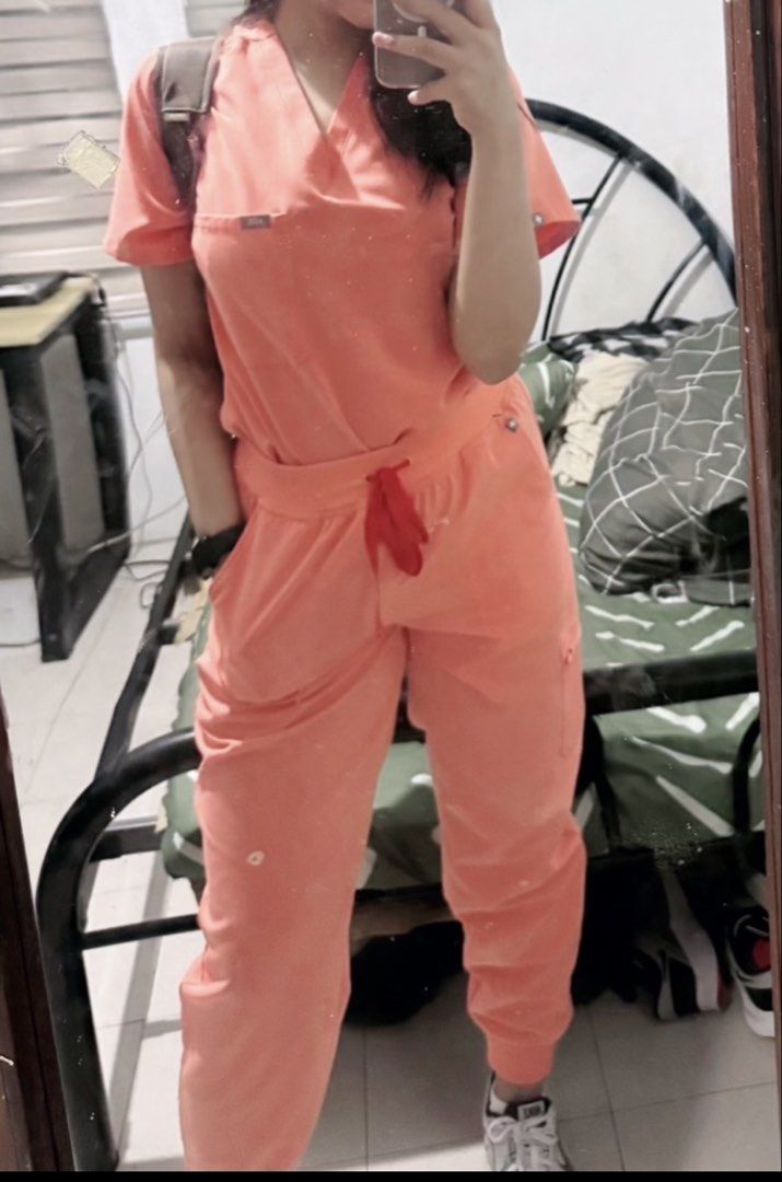 FIGS Technical Collection Peach Scrub Set (Category: Sets or Coordinates) located in Manila. Submitted by alyberi (Listing ID 1470239125, Image 3). Description: - Authentic FIGS scrub set from the Technical Collection in a gorgeous Peach shade - Used once - V-neck top includes a convenient chest pocket and signature FIGS logo tag - Matching Zamora jogger pants feature an adjustable drawstring waist, practical pockets, and stylish ribbed cuffs - M