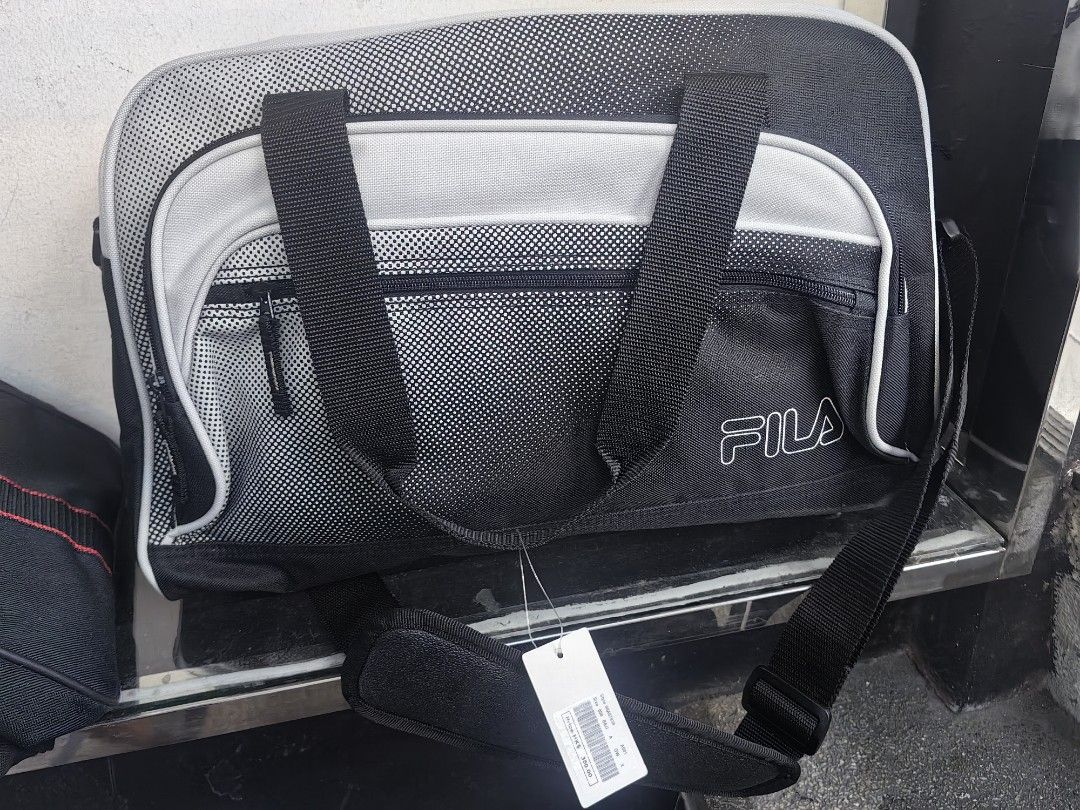 FILA Black and Grey Duffle Bag with Shoulder Strap (Category: Sling Bags) located in Quezon City. Submitted by flat.earther23 (Listing ID 1470242334, Image 1). Description: - Brand: FILA - Condition: Brand new with tag attached - Color: Black and grey - Storage: Spacious interior for gym gear or short trips, plus a front zip pocket - Carrying Options: Double carry handles and an adjustable shoulder strap with FILA logo print.