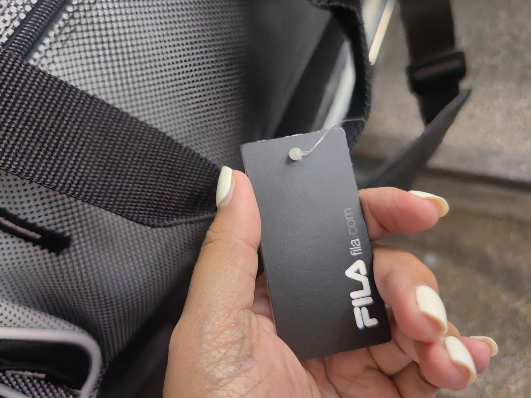 FILA Black and Grey Duffle Bag with Shoulder Strap (Category: Sling Bags) located in Quezon City. Submitted by flat.earther23 (Listing ID 1470242334, Image 2). Description: - Brand: FILA - Condition: Brand new with tag attached - Color: Black and grey - Storage: Spacious interior for gym gear or short trips, plus a front zip pocket - Carrying Options: Double carry handles and an adjustable shoulder strap with FILA logo print.