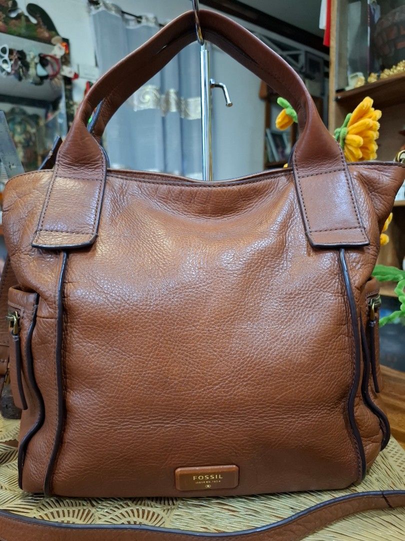 Fossil Brown Leather Shoulder Bag Handbag (Category: Shoulder Bags) located in Libon. Submitted by jaladzarmi80045 (Listing ID 1470237034, Image 2). Description: - Brand: Fossil - Material: Genuine pebbled leather in rich brown with dark brown trim - Hardware: Gold-tone with front logo plaque - Straps: Double top handles and an adjustable/detachable shoulder strap - Closure & Pockets: Zip top closure with an exterior side zip pocket.