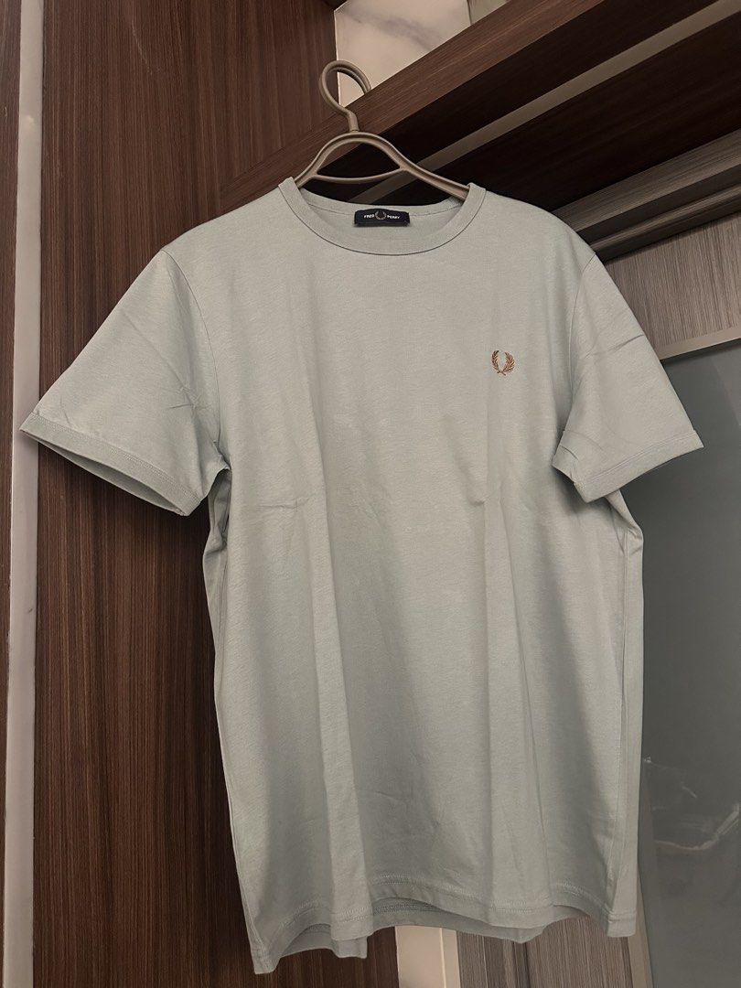Fred Perry Green T-Shirt Size L (Category: Tshirts & Polo Shirts ) located in Quezon City. Submitted by adc2011 (Listing ID 1470229053, Image 1). Description: - Brand: Fred Perry - Item: Crewneck T-Shirt - Color: Muted light green with bronze embroidered laurel wreath logo - Size: Large - Details: Short sleeves, ribbed collar - Condition: Clean, excellent, ready to wear - Style: Classic casual streetwear basic.