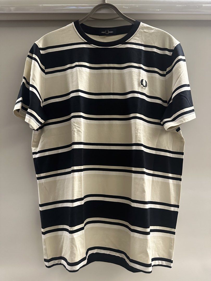 Fred Perry Striped T-Shirt Size L (Category: Tshirts & Polo Shirts ) located in Quezon City. Submitted by adc2011 (Listing ID 1470229101, Image 1). Description: - Brand: Fred Perry - Design: Bold black, white, and beige horizontal stripes - Logo: Classic embroidered laurel wreath on left chest - Material: Soft cotton fabric with ribbed collar and sleeve cuffs - Size: L (inner collar tag) - Condition: Clean, excellent, and ready to wear.