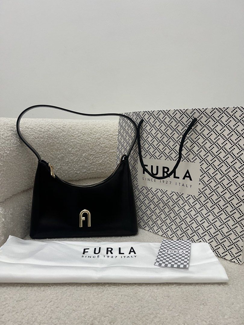 Furla Diamante Black Shoulder Bag (Category: Luxury Bags & Wallets) located in Abulug. Submitted by jamiecammie (Listing ID 1470274085, Image 1). Description: - Brand: Furla - Material: Premium black leather - Hardware: Gold-tone with zip closure and logo pull tab - Design: Features the iconic Furla arch logo on the front .