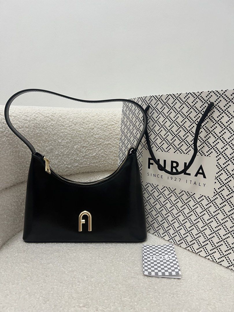 Furla Diamante Black Shoulder Bag (Category: Luxury Bags & Wallets) located in Abulug. Submitted by jamiecammie (Listing ID 1470274085, Image 2). Description: - Brand: Furla - Material: Premium black leather - Hardware: Gold-tone with zip closure and logo pull tab - Design: Features the iconic Furla arch logo on the front .
