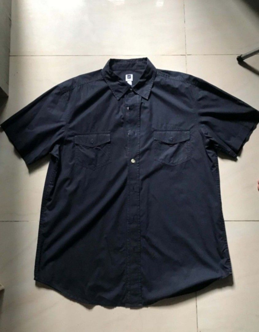 GAP Short Sleeve Button Down (Navy/Black) (Category: Tshirts & Polo Shirts ) located in Paranaque City. Submitted by genxie_ (Listing ID 1470238661, Image 3). Description: Brand: GAP Size on Tag: L Measurements: Length 30" | Width 23" Condition: Good condition, no fading or discoloration Details: Dual chest flap pockets, white contrast buttons, classic collar Model Specs: 5'5" / 49 kg (shown wearing for fit reference).