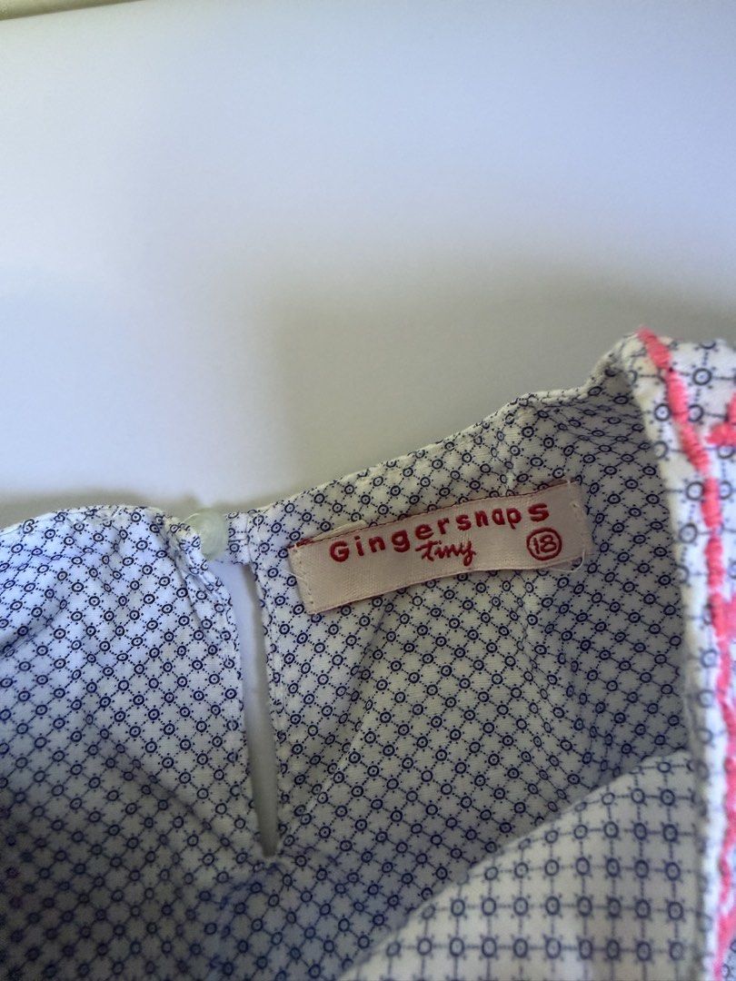 Gingersnaps Tiny Embroidered Blouse Size 18 (Category: Babies & Kids Fashion) located in General Santos City (Dadiangas). Submitted by my_lzlove (Listing ID 1470239132, Image 2). Description: - Brand/Style: Gingersnaps Tiny top - Size: 18 - Design: White fabric with dark blue geometric pattern and bright pink embroidery - Features: Short flutter sleeves and back neck button closure - Material: Soft, lightweight cotton ideal for warm weather.