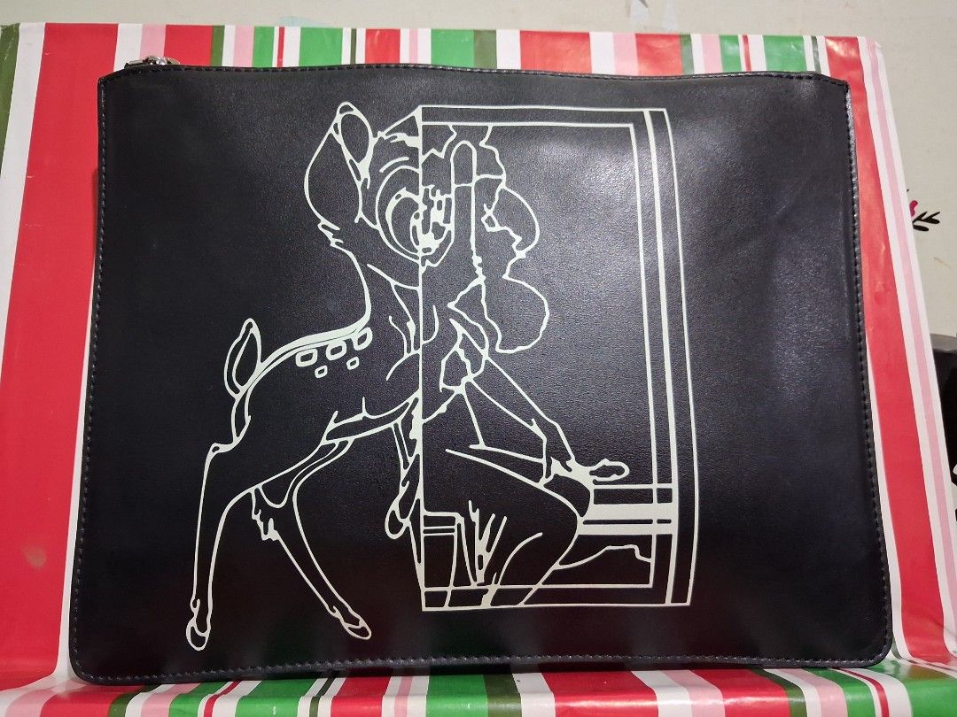 Givenchy Bambi Graphic Leather Clutch (Category: Luxury Bags & Wallets) located in Hinigaran. Submitted by faye_fab (Listing ID 1470268001, Image 3). Description: - Brand: Givenchy Paris - Material: Premium black leather with smooth matte finish - Design: Iconic Bambi and graphic line artwork on front - Branding: Embossed Givenchy logo near the top edge on the back - Hardware: Silver-tone zip pull with secure top zip closure - Interior: Spacious 