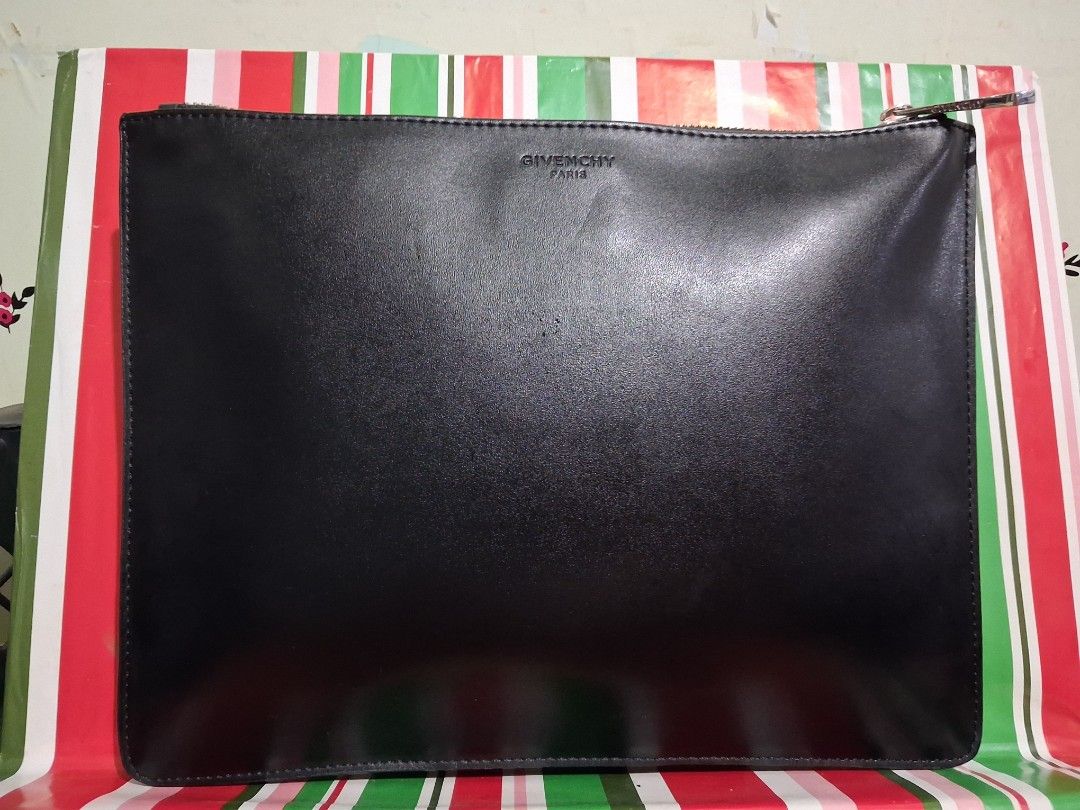 Givenchy Bambi Graphic Leather Clutch (Category: Luxury Bags & Wallets) located in Hinigaran. Submitted by faye_fab (Listing ID 1470268001, Image 2). Description: - Brand: Givenchy Paris - Material: Premium black leather with smooth matte finish - Design: Iconic Bambi and graphic line artwork on front - Branding: Embossed Givenchy logo near the top edge on the back - Hardware: Silver-tone zip pull with secure top zip closure - Interior: Spacious 