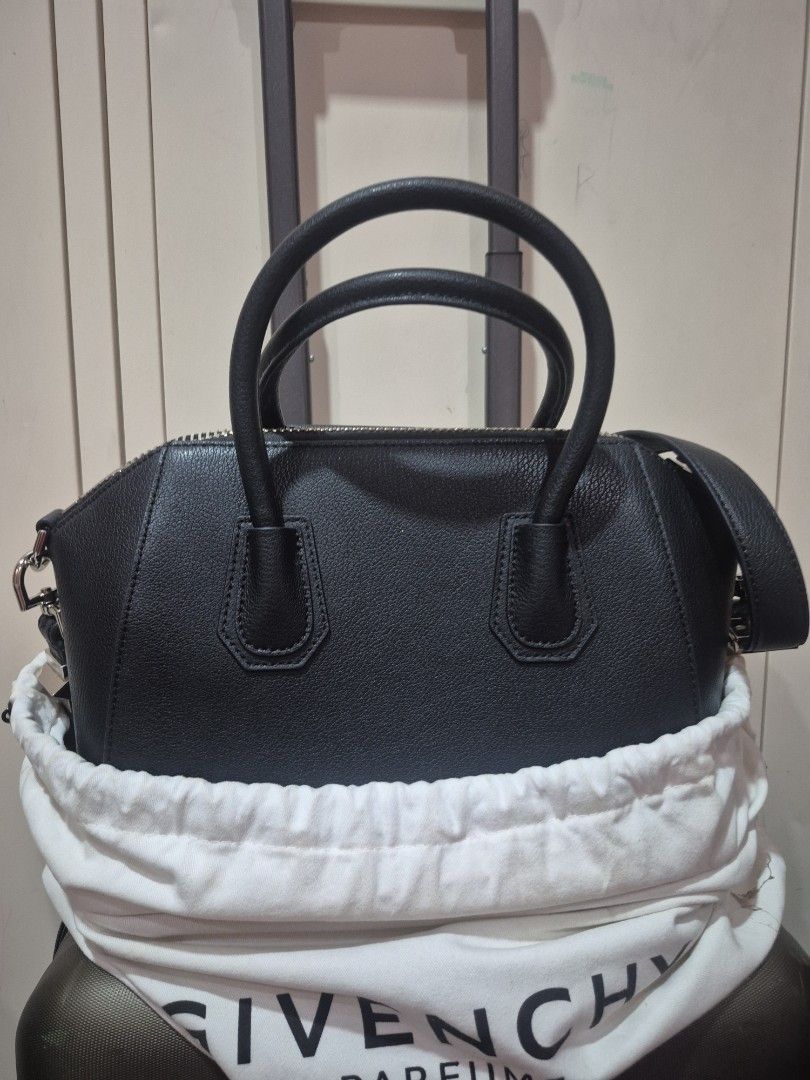 Givenchy Black Leather Antigona Handbag (Category: Luxury Bags & Wallets) located in Iloilo. Submitted by gorgeoustatz (Listing ID 1470289206, Image 3). Description: - Givenchy black leather handbag - Premium pebbled leather finish with sturdy stitching - Elegant gold-tone hardware and rolled top handles - Iconic triangular logo patch on the front - Secure double zip closure across the top - Includes original white dust bag - Condition: Excellent