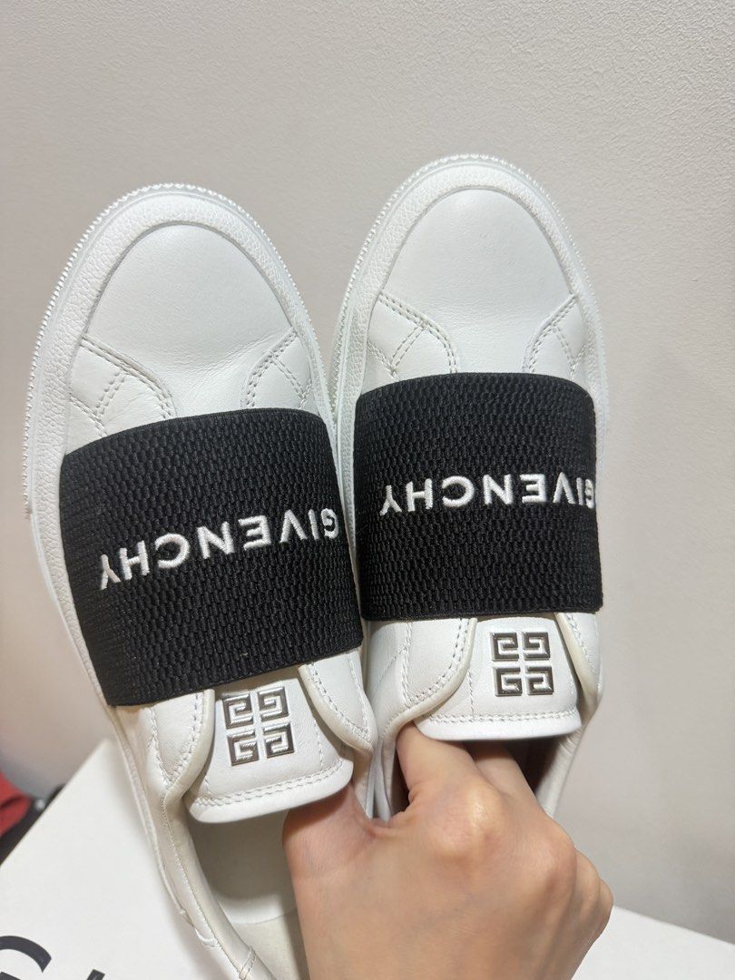 Givenchy White City Sneakers with Elastic Band (Category: Sneakers) located in Manila. Submitted by ktyyycloset (Listing ID 1470286515, Image 3). Description: - Brand: Givenchy - Color: White leather with bold black elastic strap - Features: White Givenchy branding on strap, metallic 4G logo hardware on tongue, and gold Givenchy lettering on heel counter - Inclusions: Original branded box included, dustbag and tags - Condition: Brand new with a m